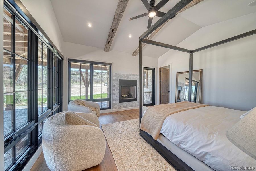 The primary suite is a private sanctuary with vaulted ceilings, exposed beams, and a contemporary fireplace. The primary suite is a private sanctuary with vaulted ceilings, exposed beams, and a contemporary fireplace.