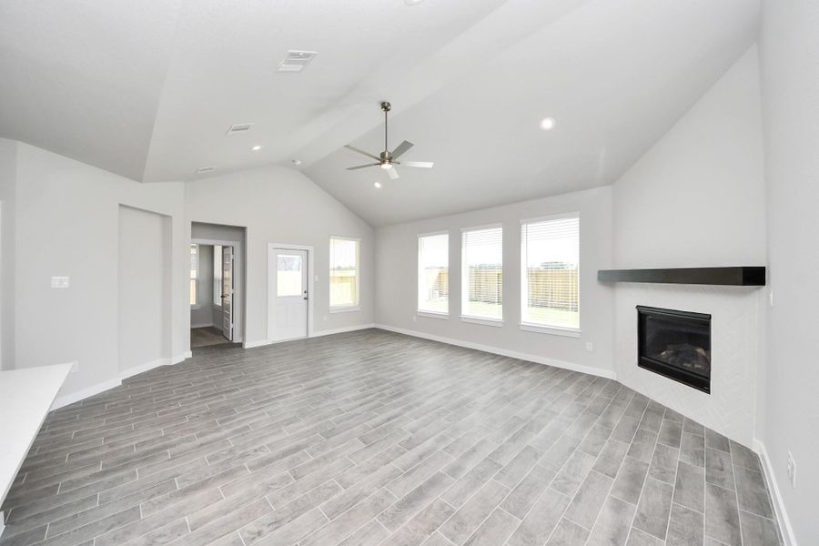 Gather the family and guests together in your lovely living room! Featuring soaring high ceilings, recessed lighting, ceiling fan, custom paint, gorgeous floors, and large windows that provide plenty of natural lighting throughout the day. Sample photo of completed home with similar floor plan. Actual colors and selections may vary. Gather the family and guests together in your lovely living room! Featuring soaring high ceilings, recessed lighting, ceiling fan, custom paint, gorgeous floors, and large windows that provide plenty of natural lighting throughout the day. Sample photo of completed home with similar floor plan. Actual colors and selections may vary.