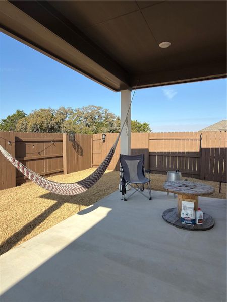 Covered patio featuring a concrete slab, recessed lighting, and a fenced yard with gravel landscaping