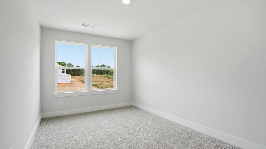 Tasteful bedroom with plush carpet, a walk-in closet, and large windows for abundant natural light in Simpsonville, SC