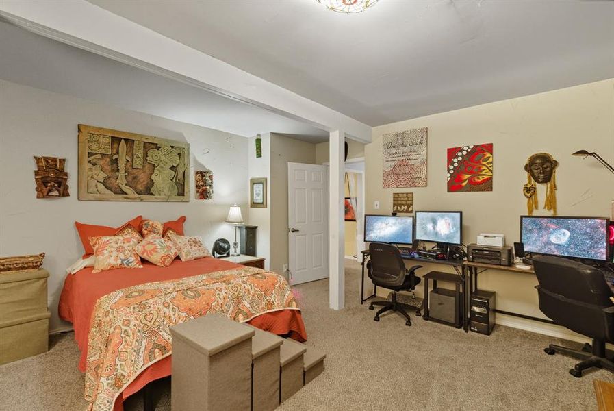 Bedroom with an office area and light colored carpet Bedroom with an office area and light colored carpet