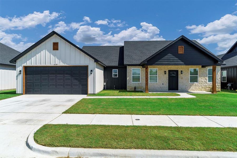 View of front of house featuring a garage and a front lawn