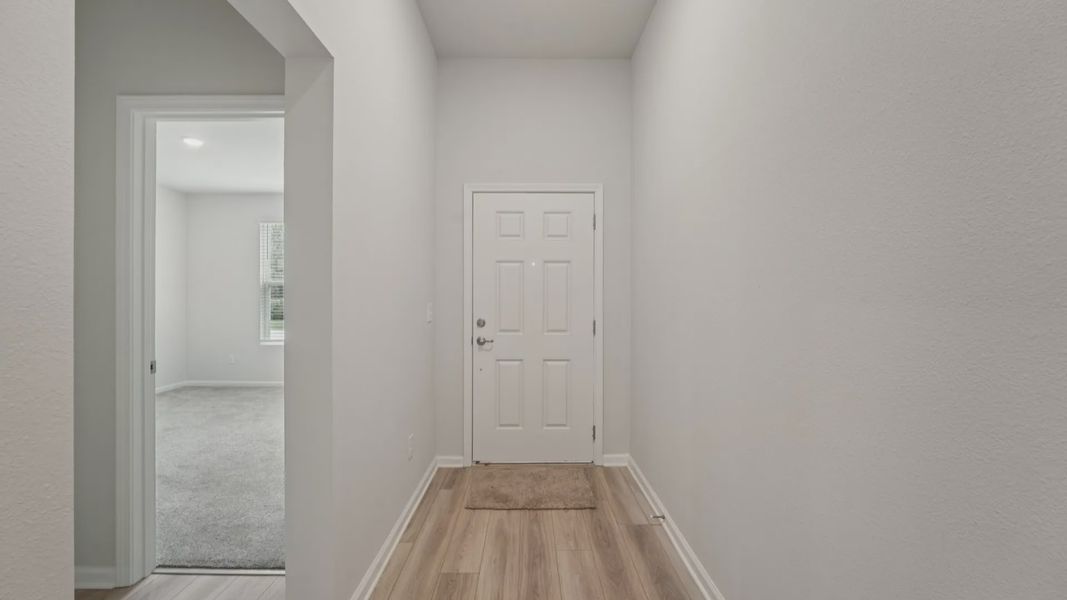 Experience refined simplicity in this Palm Coast entryway featuring luxury vinyl plank flooring and bright interiors.