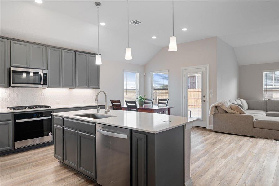 Beautiful modern kitchen is open to dining and living rooms.