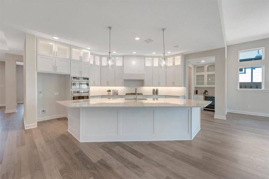 Cabinets soar to the ceiling with glass doors & LED lighting!