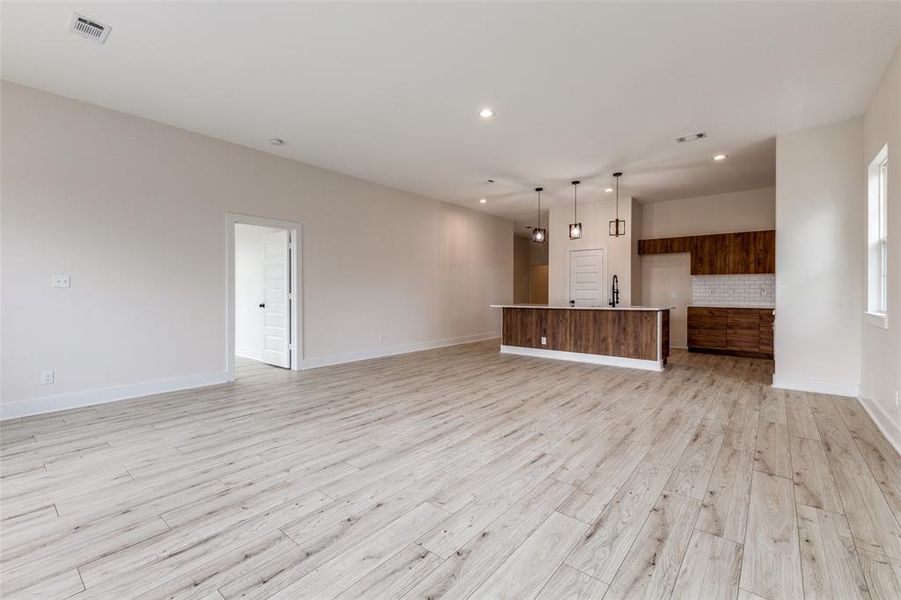 Unfurnished living room with recessed lighting, light wood-style floors, visible vents, and baseboards