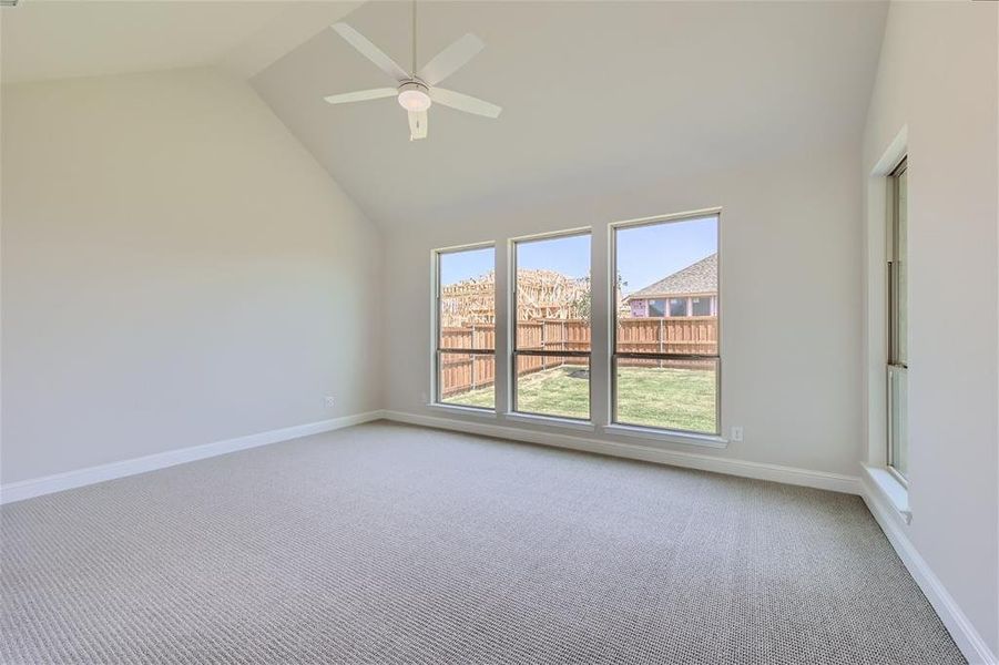 Carpeted spare room with high vaulted ceiling and ceiling fan