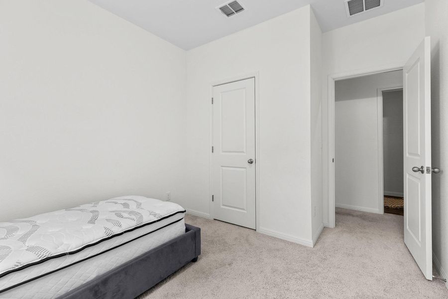 Bedroom with light colored carpet and baseboards Bedroom with light colored carpet and baseboards