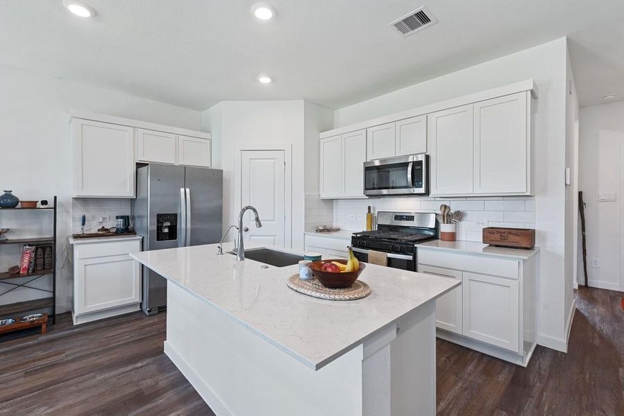 Gorgeous white cabinets and countertops provide the perfect contrast to the wood look vinyl floors!