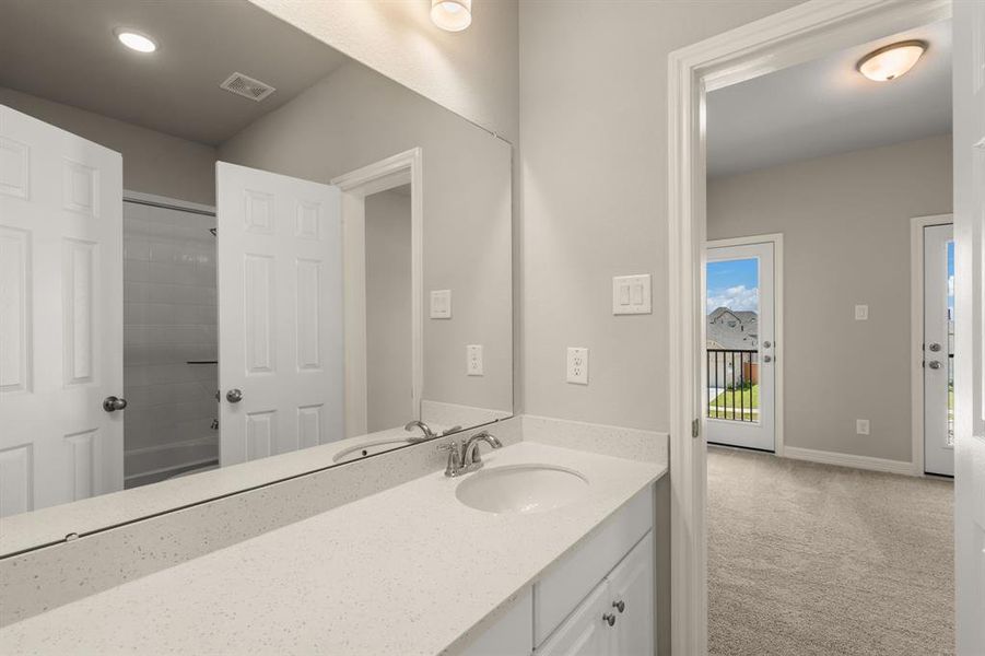 The secondary bath features tile flooring, white cabinetry and light countertops and a shower/tub combo. Perfect for accommodating any visiting family and friends.