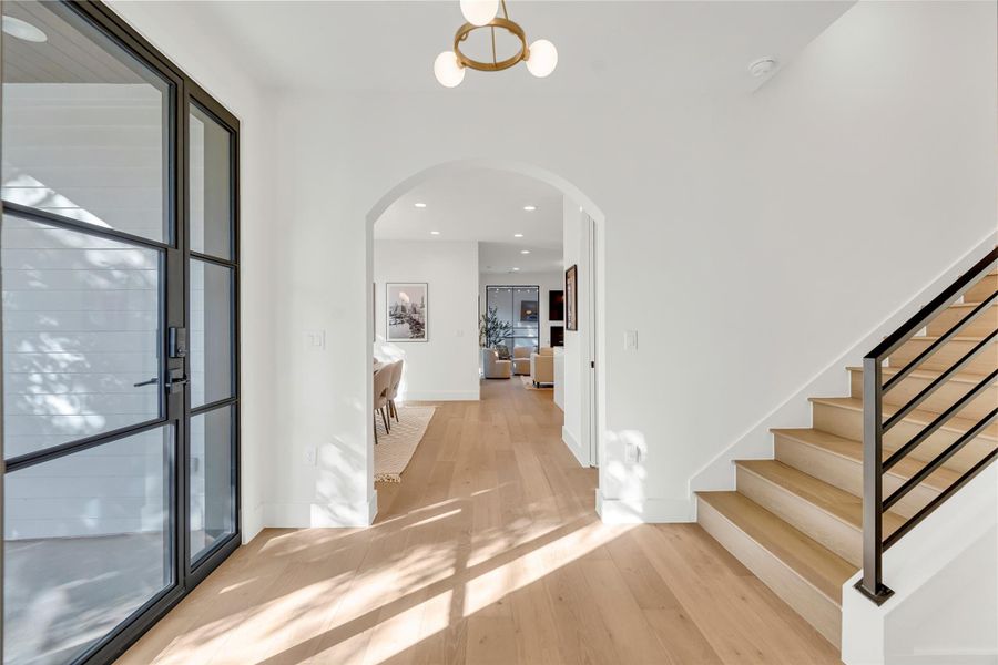 Entrance foyer with recessed lighting, arched walkways, light wood-style floors, and stairway Entrance foyer with recessed lighting, arched walkways, light wood-style floors, and stairway