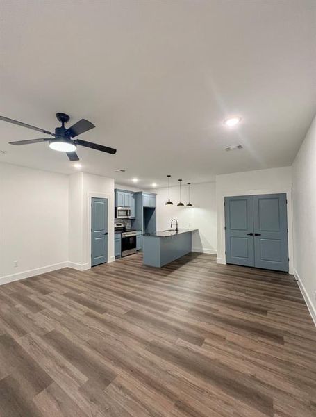 Unfurnished living room with dark hardwood / wood-style floors, sink, and ceiling fan