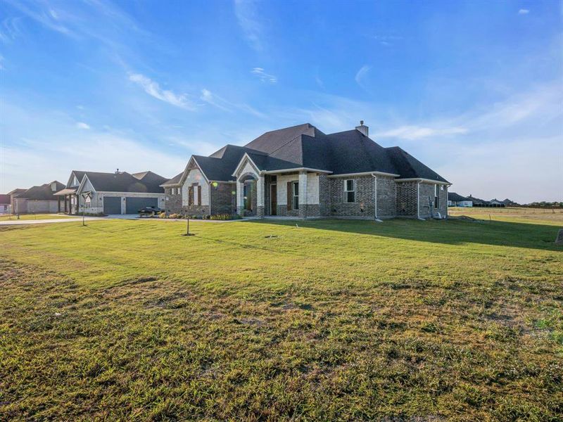 View of front of home with a front yard and a garage