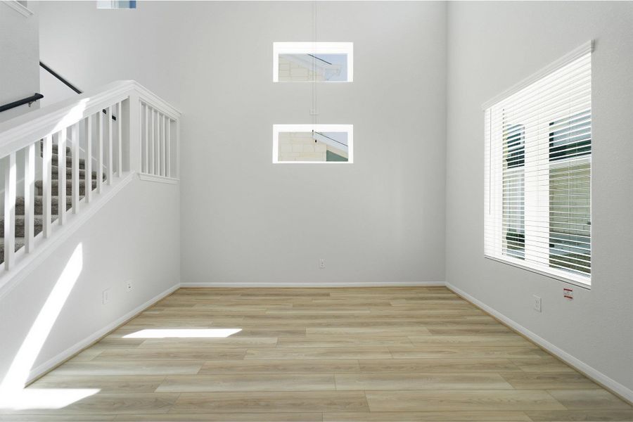 Empty room with light wood-style flooring and a high ceiling
