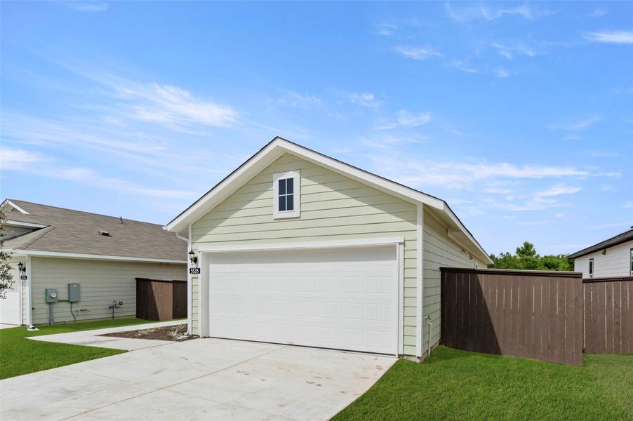 View of front of house with a garage, an outdoor structure, and driveway