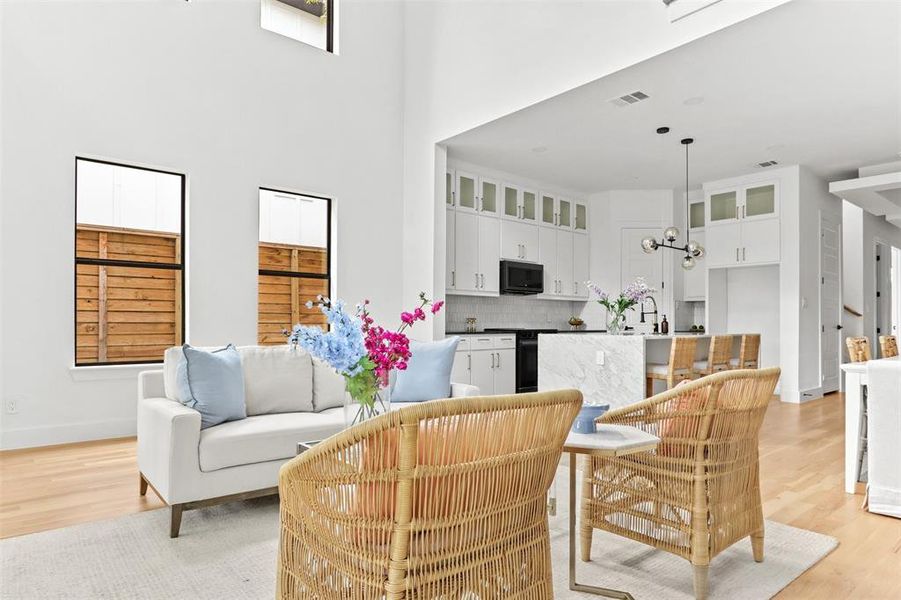 Living room with a high ceiling and light hardwood / wood-style floors