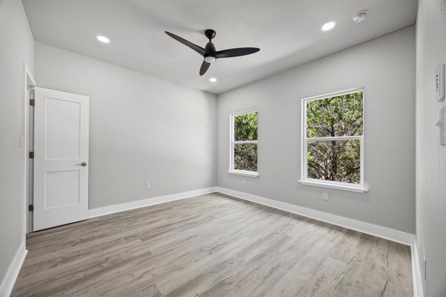 Bedroom featuring light wood finished floors, recessed lighting, and ceiling fan Bedroom featuring light wood finished floors, recessed lighting, and ceiling fan