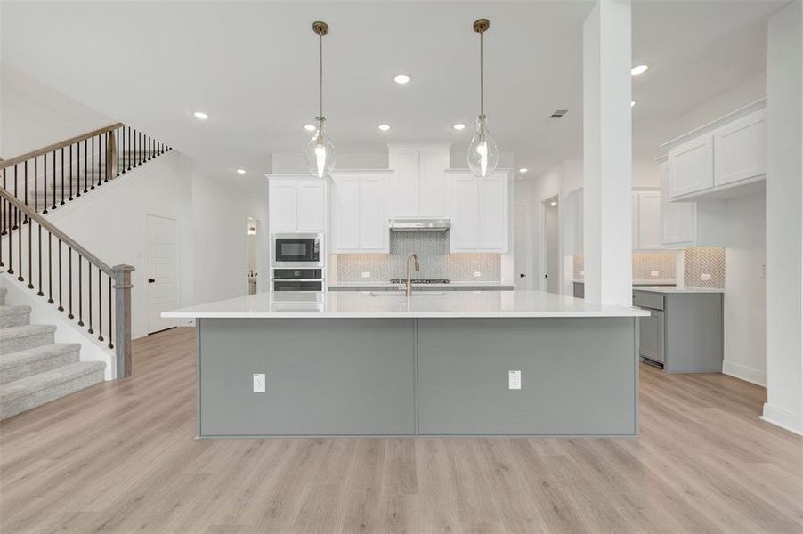 Expansive kitchen island with a light-toned countertop and contrasting base Expansive kitchen island with a light-toned countertop and contrasting base