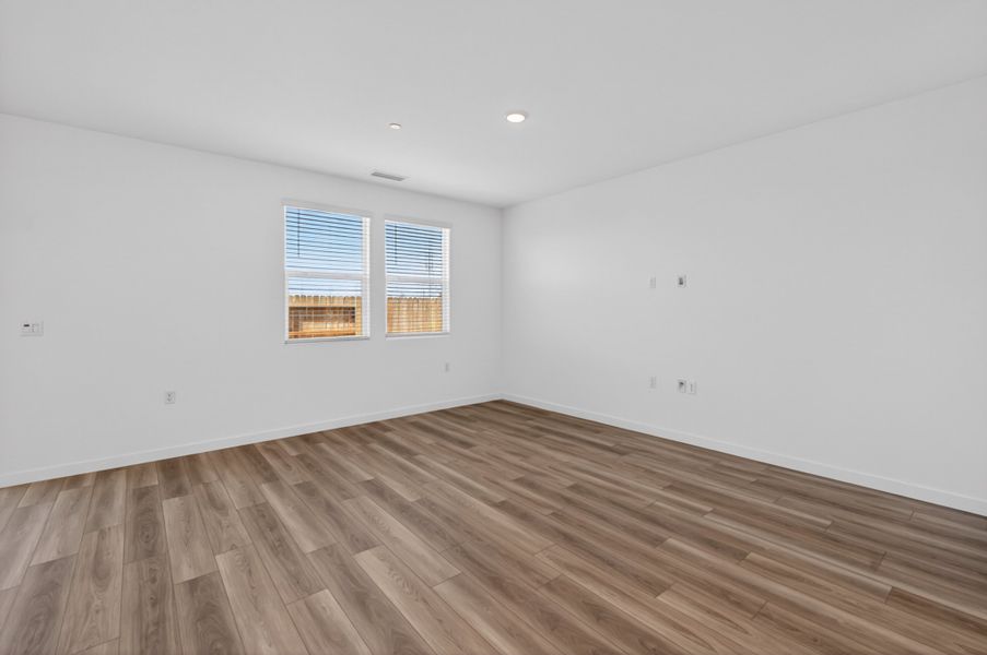 A room with a wood floor and a window. A room with a wood floor and a window.
