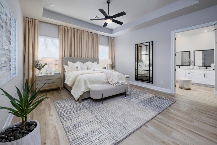 The spacious primary bedroom has beautiful ceilings and hardwood flooring.
