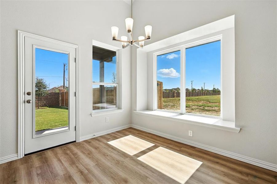Unfurnished dining area with a chandelier and wood finished floors Unfurnished dining area with a chandelier and wood finished floors