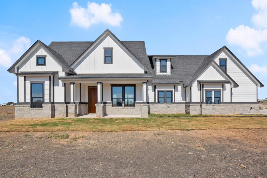 A new build with modern farmhouse appeal, featuring a striking black and white exterior and clean architectural lines. A new build with modern farmhouse appeal, featuring a striking black and white exterior and clean architectural lines.