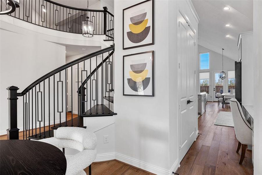 Stairs featuring baseboards, high vaulted ceiling, recessed lighting, hardwood / wood-style flooring, and a notable chandelier