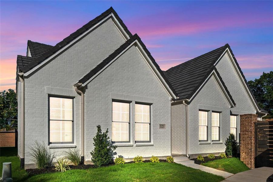 Back of property featuring brick siding and a lawn