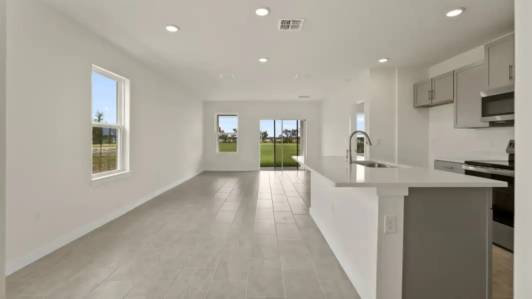 The Naples Living Room and Kitchen Island Quick Move-In Home at Willowbrook North by DRB Homes in Winter Haven, FL
