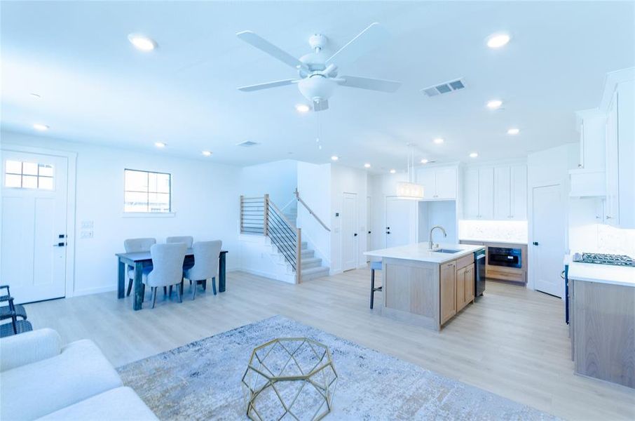 Living room with light wood finished floors, recessed lighting, and a ceiling fan