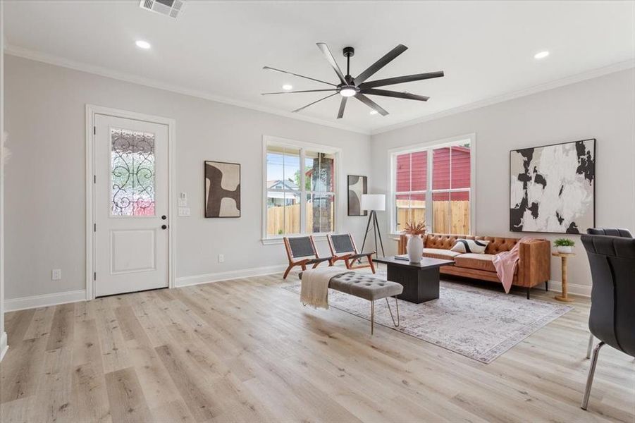 Living room with crown molding, a ceiling fan, light wood-style flooring, and recessed lighting Living room with crown molding, a ceiling fan, light wood-style flooring, and recessed lighting