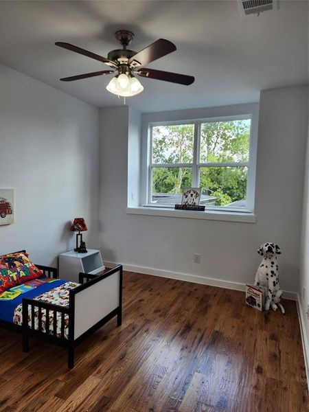 Bedroom featuring ceiling fan and dark wood-type flooring