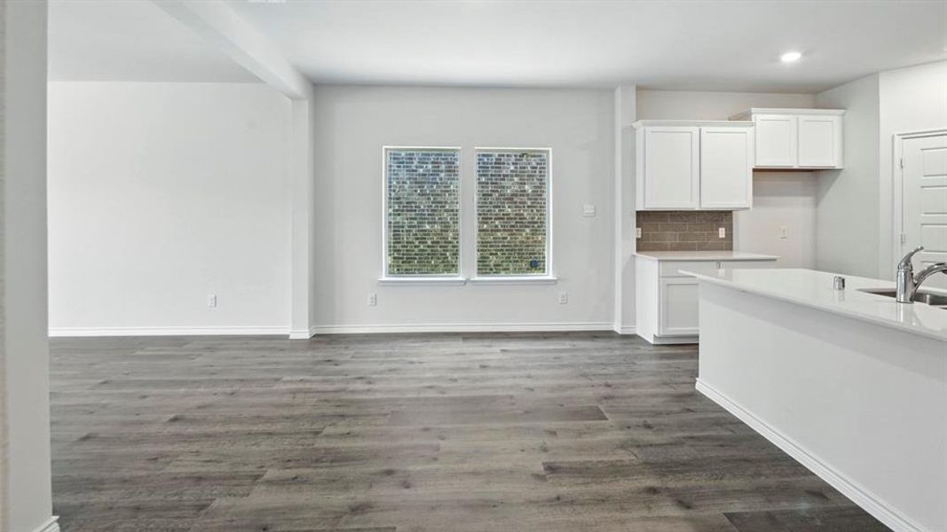 Unfurnished dining area with dark wood finished floors and baseboards Unfurnished dining area with dark wood finished floors and baseboards