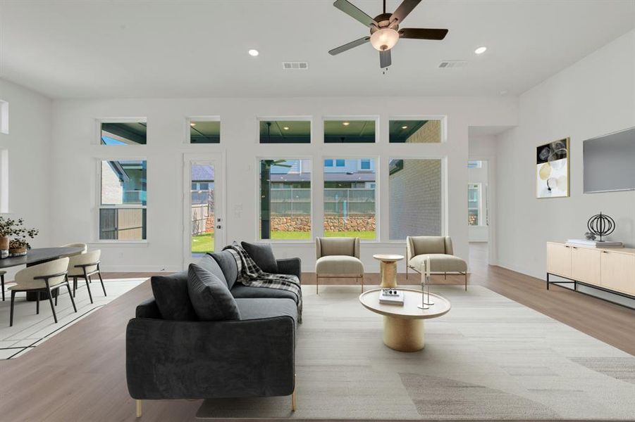 Open-concept living area featuring wood-finish flooring, a contemporary ceiling fan, and recessed lighting