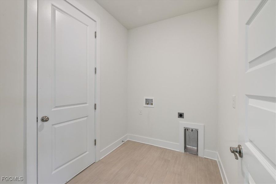 Washroom with light wood-style floors, hookup for a washing machine, and hookup for an electric dryer Washroom with light wood-style floors, hookup for a washing machine, and hookup for an electric dryer