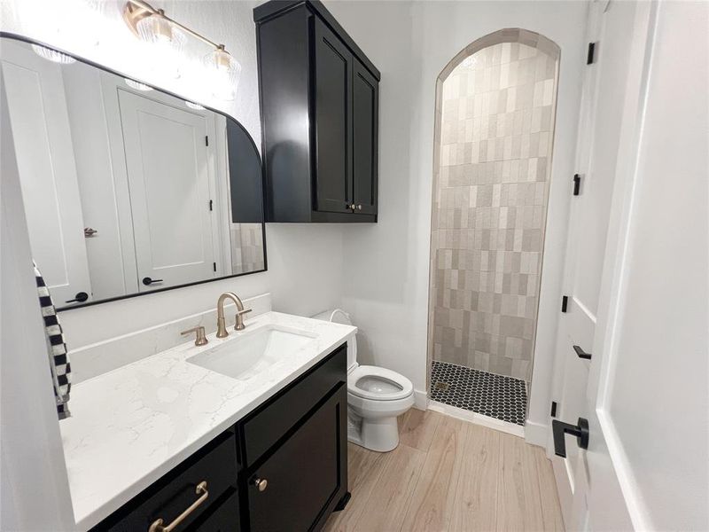 Full bath with vanity, a shower stall, and light wood-style flooring