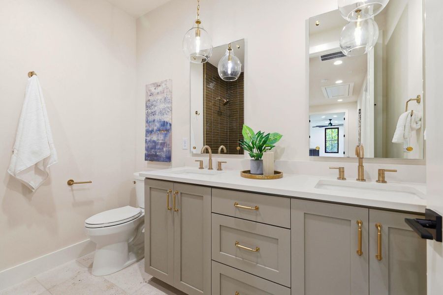 Full bath featuring double vanity, a tile shower, a ceiling fan, and light tile patterned flooring