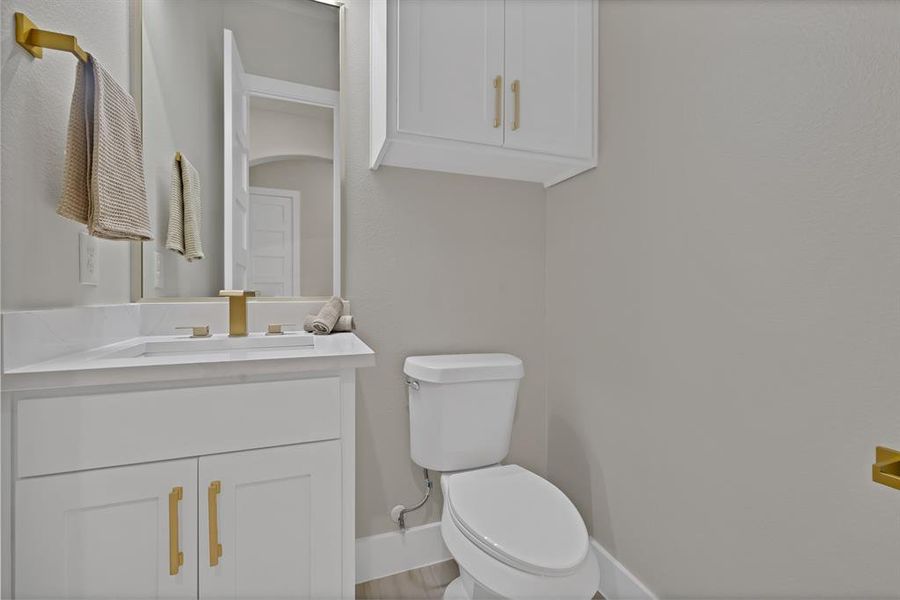 Bathroom with baseboards, vanity, and toilet Bathroom with baseboards, vanity, and toilet