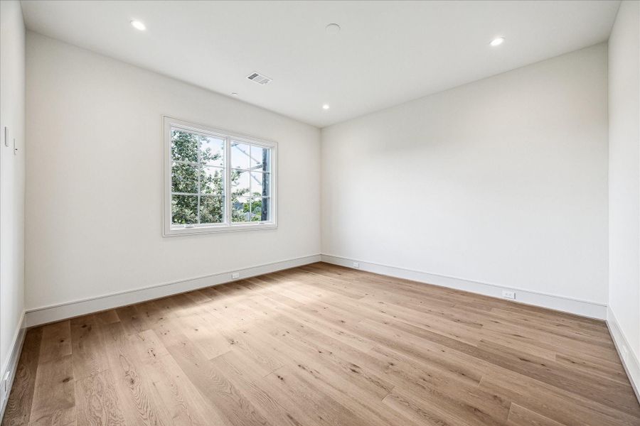 The second-floor secondary bedroom has stained white oak floors and lots of room, as well as its own en-suite bathroom.