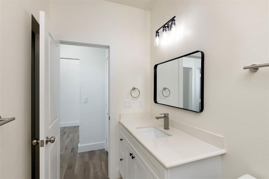Bathroom with baseboards, wood finished floors, and vanity