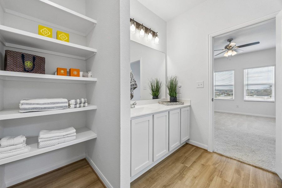 Full bathroom featuring vanity, light wood-style flooring, a ceiling fan, and a closet