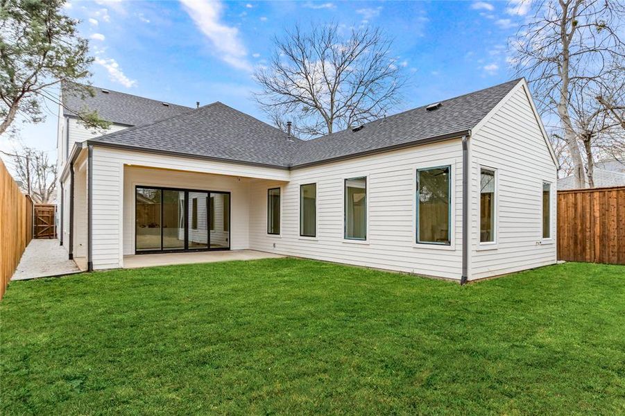 Rear view of house with a yard and a patio area