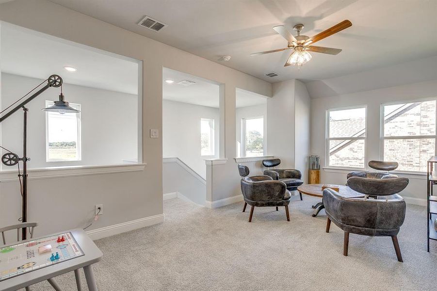 Living area featuring an upstairs landing, ceiling fan, and recessed lighting