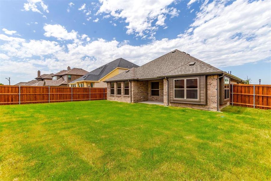 Back of property featuring a patio and a lawn