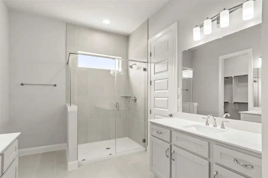 Full bath with vanity, a stall shower, a spacious closet, tile patterned floors, and recessed lighting Full bath with vanity, a stall shower, a spacious closet, tile patterned floors, and recessed lighting