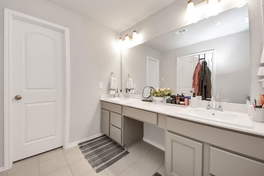 Another dual sink and vanity view in the primary bath room. Door leads to an amazing walk-in closet. Note all hard surface flooring in the bath room. Another dual sink and vanity view in the primary bath room. Door leads to an amazing walk-in closet. Note all hard surface flooring in the bath room.