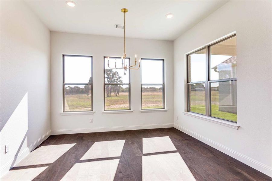 Unfurnished dining area featuring dark wood finished floors, a chandelier, and recessed lighting Unfurnished dining area featuring dark wood finished floors, a chandelier, and recessed lighting