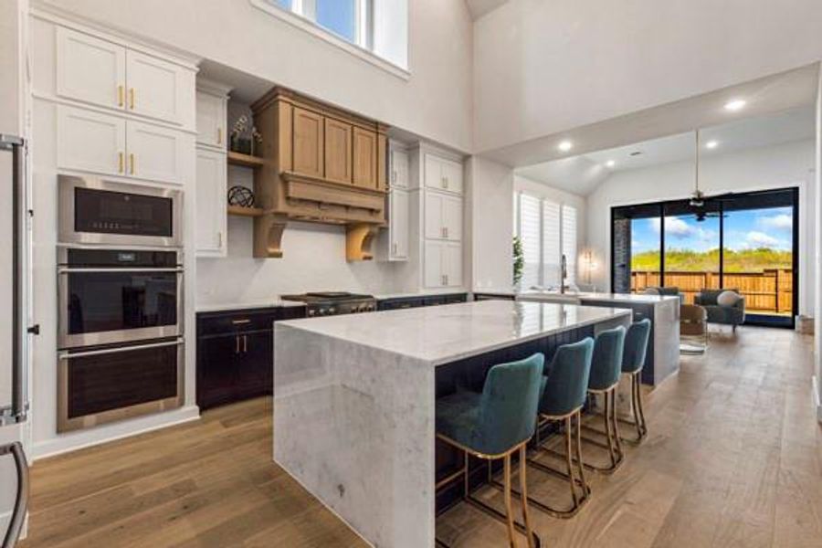 Kitchen with plenty of natural light, white cabinets, dark wood-type flooring, a kitchen bar, and recessed lighting