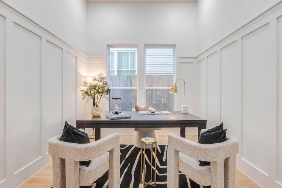 Ideal for a quiet workspace or reading room, this sophisticated study features custom wall paneling, tall ceilings, and abundant natural light from large double windows.