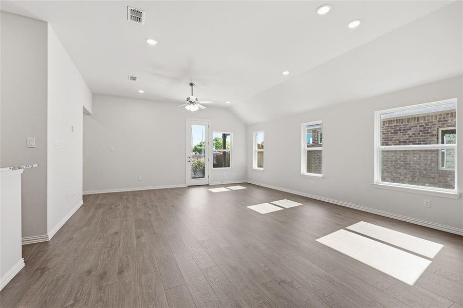 Spare room with vaulted ceiling, dark wood-type flooring, ceiling fan, and recessed lighting Spare room with vaulted ceiling, dark wood-type flooring, ceiling fan, and recessed lighting